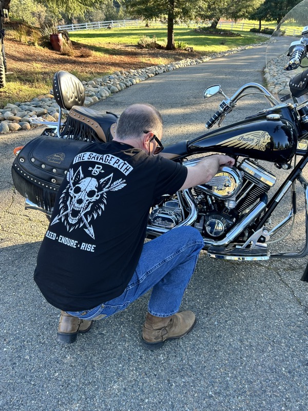 Man crouching next to motorcycle